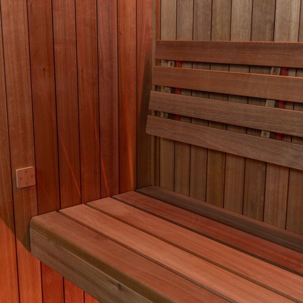 Element Studio indoor sauna interior corner showing wood wall panels, bench and slatted backrest.