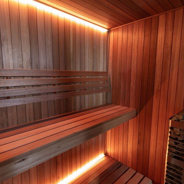 Element Studio indoor sauna with wood benches, optional lighting and partially visible heater (sold separately).